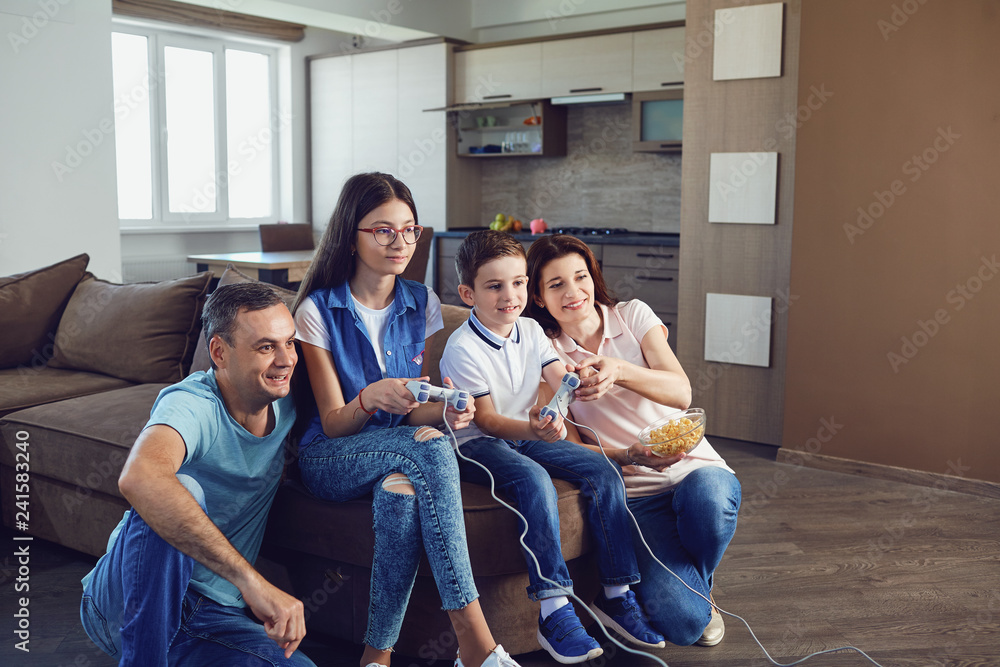 A cheerful family is playing video games in the house. A cheerful family is playing video games in the house.