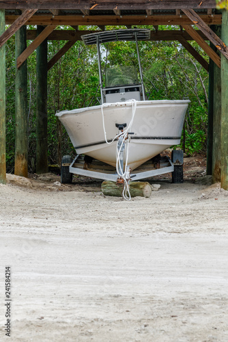 boat on a trailer stored under a conopy near the beach photo