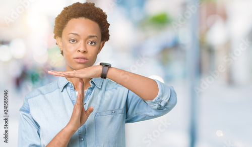 Young beautiful african american woman over isolated background Doing time out gesture with hands, frustrated and serious face