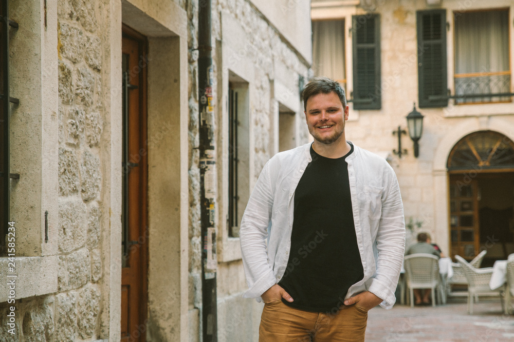 young stylish man walking by tight Kotor street. Montenegro young stylish man walking by tight Kotor street. Montenegro