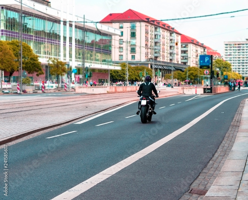 Wallpaper Mural Motorcycle driver, motorcyclist, moves on the road of the city. Blurred background, view from the back. Torontodigital.ca