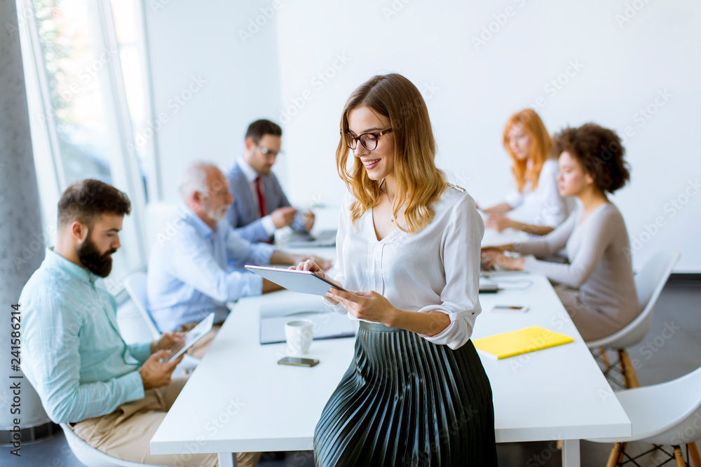 Fototapeta premium Elegant businesswoman standing in office with digital tablet