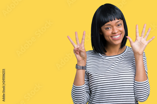 Beautiful young african american woman wearing stripes sweater over isolated background showing and pointing up with fingers number eight while smiling confident and happy.