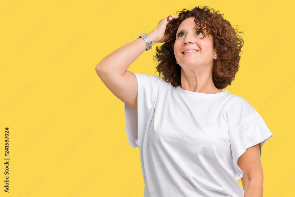 Beautiful middle ager senior woman wearing white t-shirt over isolated background Smiling confident touching hair with hand up gesture, posing attractive Beautiful middle ager senior woman wearing white t-shirt over isolated background Smiling confident touching hair with hand up gesture, posing attractive