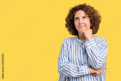 Beautiful middle ager senior woman wearing navy shirt over isolated background with hand on chin thinking about question, pensive expression. Smiling with thoughtful face. Doubt concept.