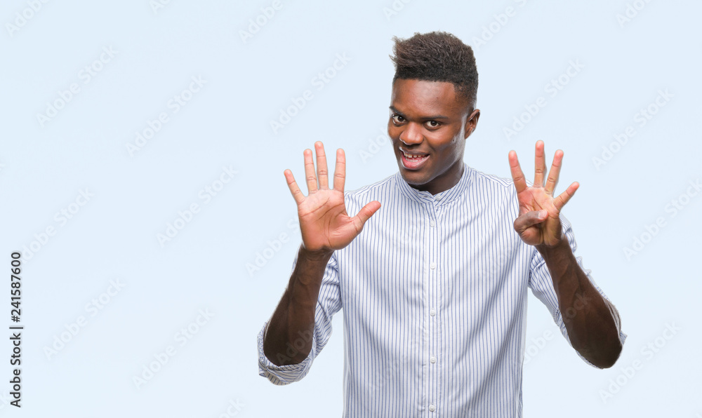 Naklejka premium Young african american man over isolated background showing and pointing up with fingers number nine while smiling confident and happy.