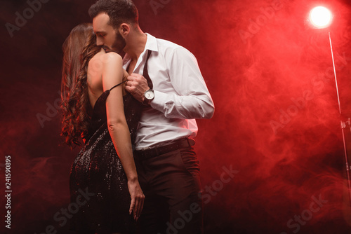 passionate seductive couple in red smoky room photo