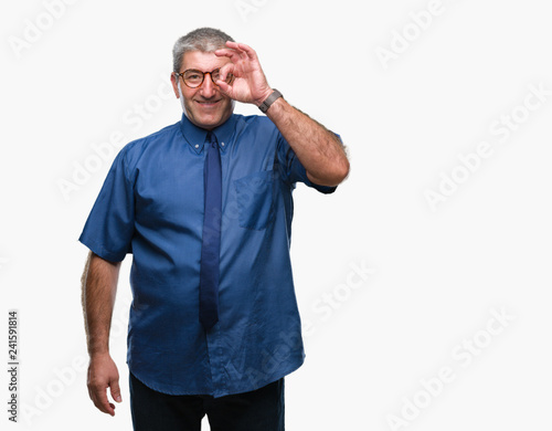 Handsome senior business man over isolated background doing ok gesture with hand smiling, eye looking through fingers with happy face.
