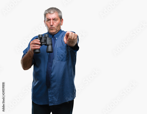 Handsome senior man looking through binoculars over isolated background pointing with finger to the camera and to you, hand sign, positive and confident gesture from the front