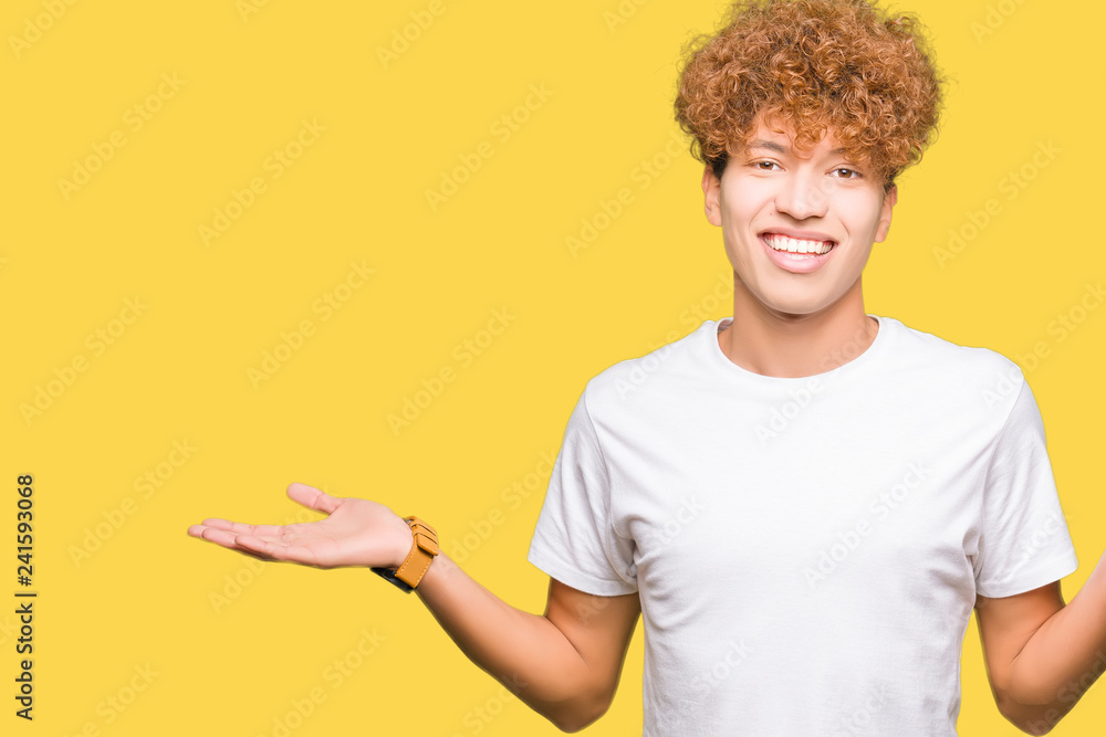 Young handsome man with afro hair wearing casual white t-shirt Smiling showing both hands open palms, presenting and advertising comparison and balance Young handsome man with afro hair wearing casual white t-shirt Smiling showing both hands open palms, presenting and advertising comparison and balance
