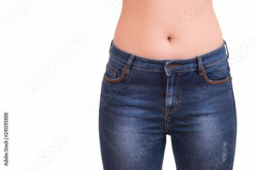 Girl in blue jeans on a white background. Woman wearing jeans pants in front. Female bottom in tight jeans. Slim waist girl in blue jeans. © fortton