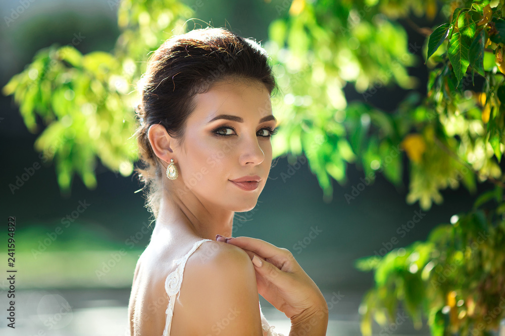 fashion photo of beautiful woman with dark hair in luxurious wedding dress posing outdoor. fashion photo of beautiful woman with dark hair in luxurious wedding dress posing outdoor.