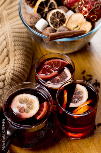 glasses of mulled wine with dry citrus and spices ,knitted sweater.