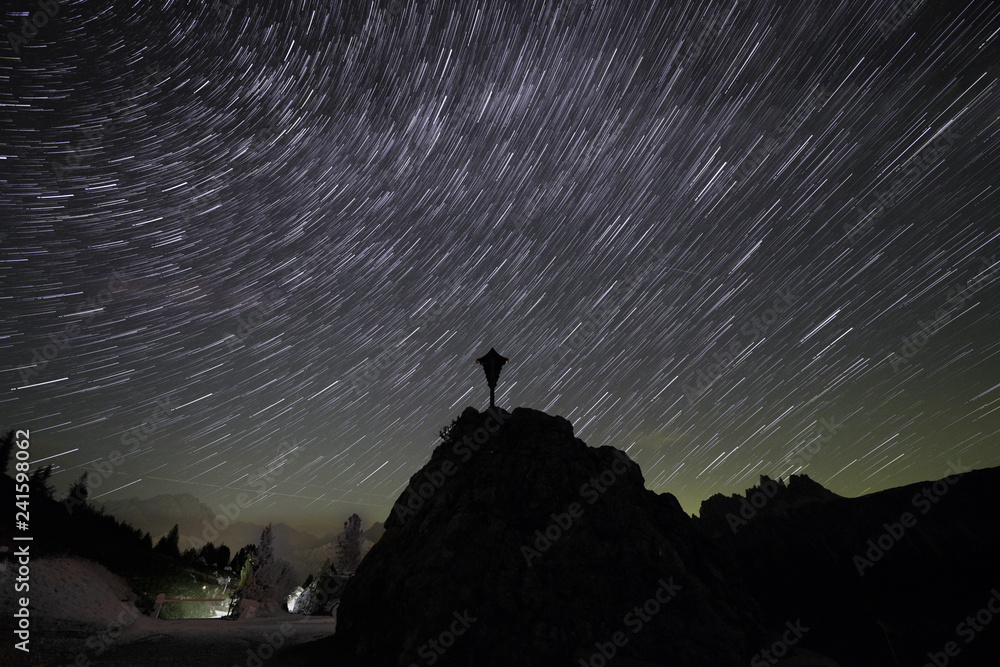 mountain star trail with religious symbol in the foreground.
