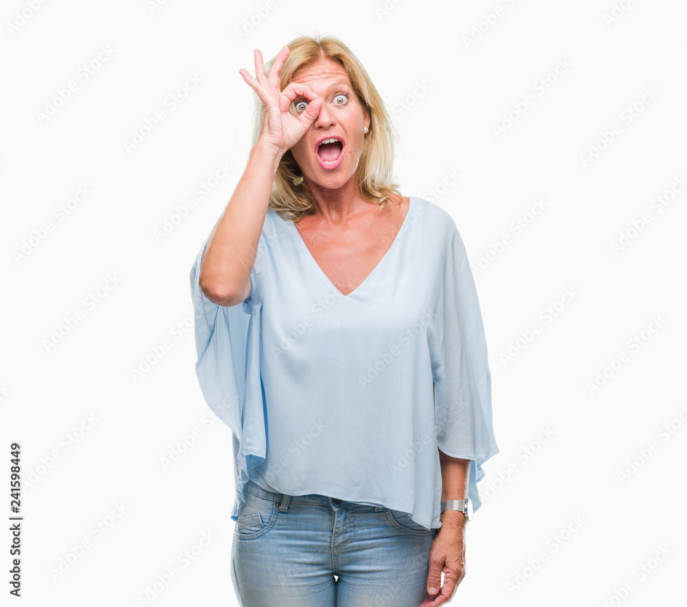 Middle age blonde business woman over isolated background doing ok gesture shocked with surprised face, eye looking through fingers. Unbelieving expression. Middle age blonde business woman over isolated background doing ok gesture shocked with surprised face, eye looking through fingers. Unbelieving expression.