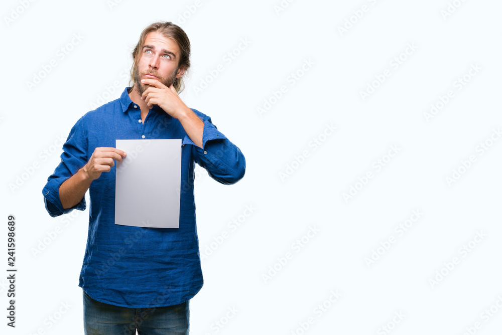 Young handsome man with long hair over isolated background holding blank paper serious face thinking about question, very confused idea Young handsome man with long hair over isolated background holding blank paper serious face thinking about question, very confused idea