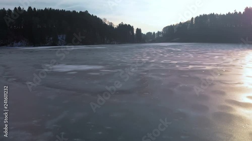 Aerial view of a frozen little Lake in Switzerland at a sunny winter Day