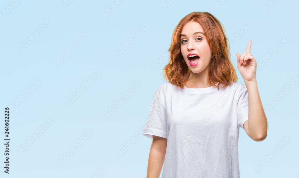 Fototapeta premium Young beautiful woman over isolated background pointing finger up with successful idea. Exited and happy. Number one.