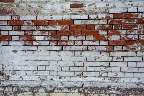 Texture of red brickwork with peeled white paint