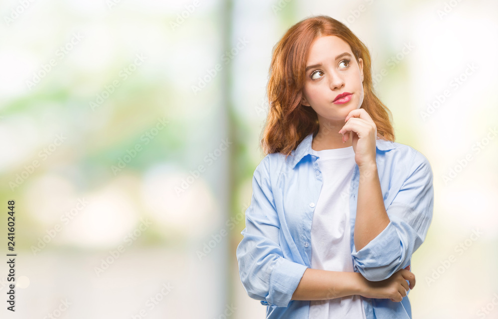 Fototapeta premium Young beautiful business woman over isolated background with hand on chin thinking about question, pensive expression. Smiling with thoughtful face. Doubt concept.