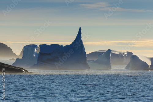 Icebergs and sea mist, entrance to Skjoldungen Fjord, early morning, King Frederick VI Coast, remote South East Greenland, Denmark photo