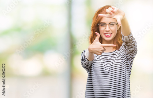 Young beautiful woman over isolated background wearing glasses smiling making frame with hands and fingers with happy face. Creativity and photography concept.