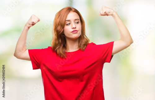 Young beautiful woman over isolated background showing arms muscles smiling proud. Fitness concept.