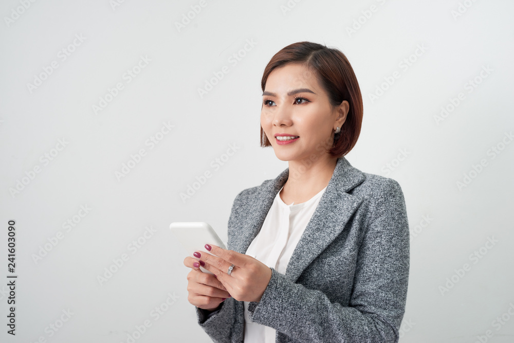 Smiling businesswoman using smartphone over white background. Smiling businesswoman using smartphone over white background.