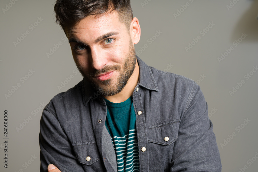 Obraz premium Young handsome man possing and modeling over grey isolated background