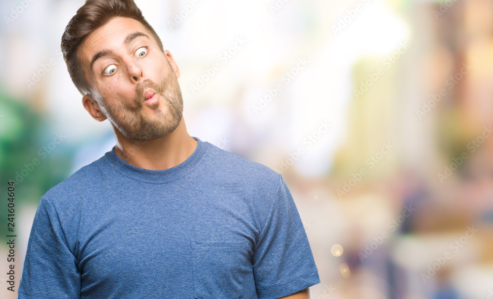 Young handsome man over isolated background making fish face with lips, crazy and comical gesture. Funny expression. Young handsome man over isolated background making fish face with lips, crazy and comical gesture. Funny expression.