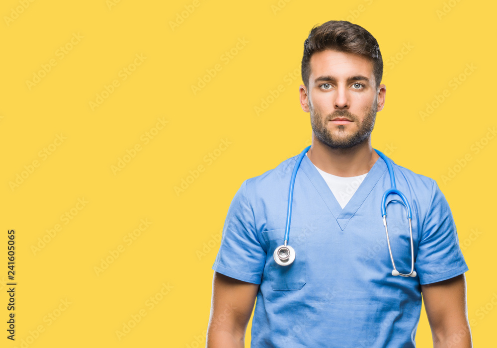 Young handsome doctor man over isolated background with serious expression on face. Simple and natural looking at the camera. Young handsome doctor man over isolated background with serious expression on face. Simple and natural looking at the camera.