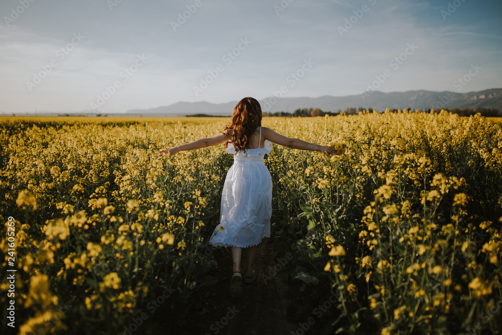 Rear view of woman in white dress walking in field Rear view of woman in white dress walking in field