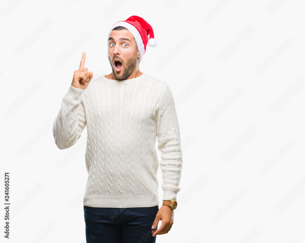 Young handsome man wearing santa claus hat over isolated background pointing finger up with successful idea. Exited and happy. Number one. Young handsome man wearing santa claus hat over isolated background pointing finger up with successful idea. Exited and happy. Number one.