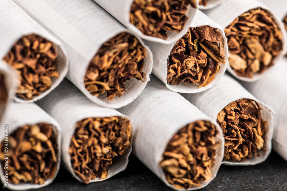 Close-up of tobacco cigarettes on a black background. Close-up of tobacco cigarettes on a black background.
