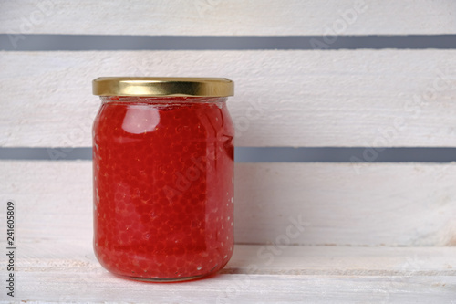 Photography Red caviar in big glass jar on white shelf