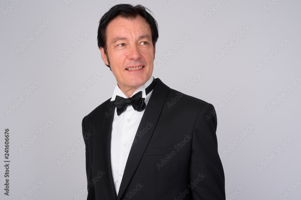 Happy mature handsome businessman smiling and thinking Happy mature handsome businessman smiling and thinking