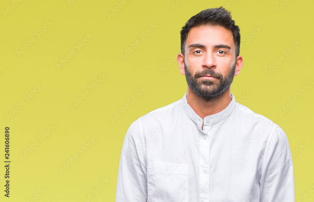 Adult hispanic man over isolated background with serious expression on face. Simple and natural looking at the camera. Adult hispanic man over isolated background with serious expression on face. Simple and natural looking at the camera.