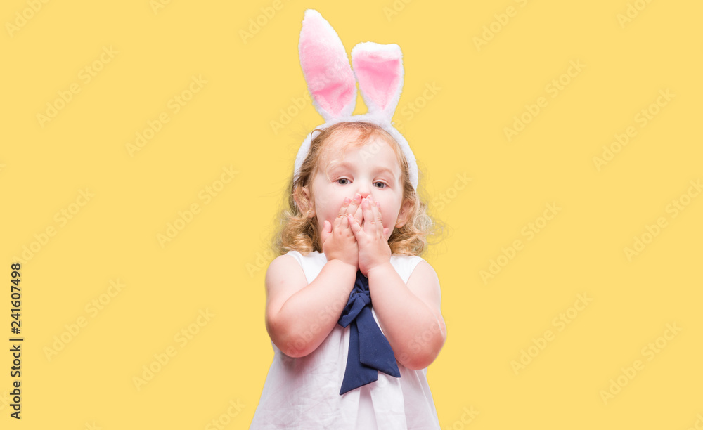 Lovely blonde toddler wearing easter bunny ears