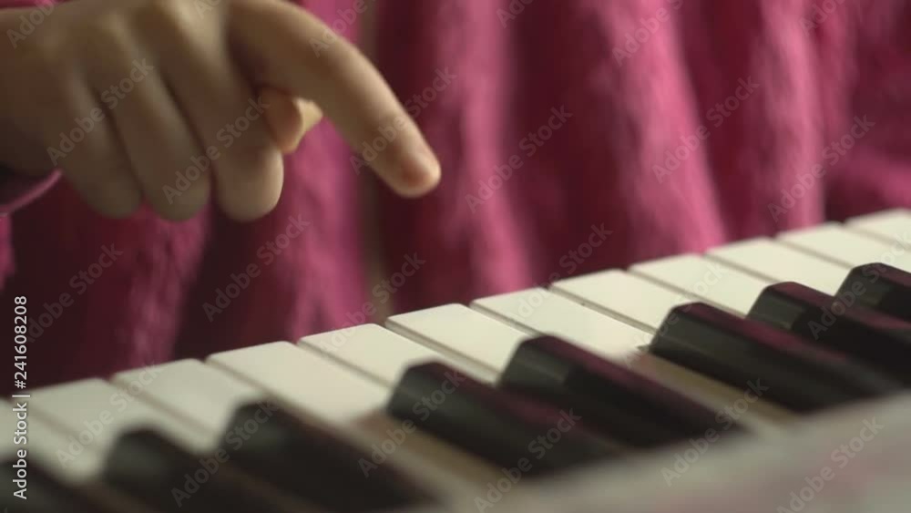 The girl plays the piano. Little girl learns to play piano The girl plays the piano. Little girl learns to play piano