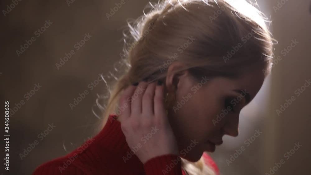 Beautiful fashion model in red dress posing with earrings, attractive luxury girl Beautiful fashion model in red dress posing with earrings, attractive luxury girl