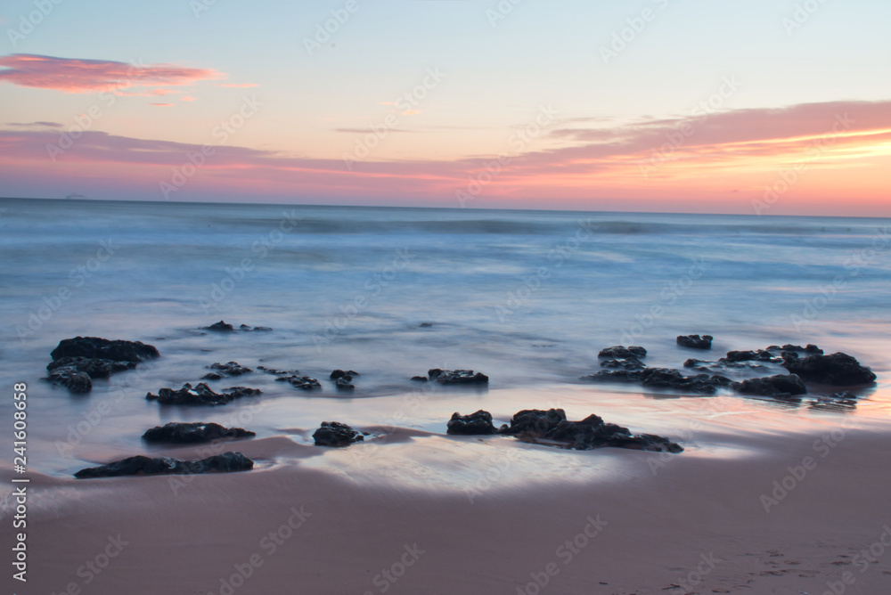 Beautiful Calming Sunrise Vacation Landscape Warm Colors Rocks on Shore Coast