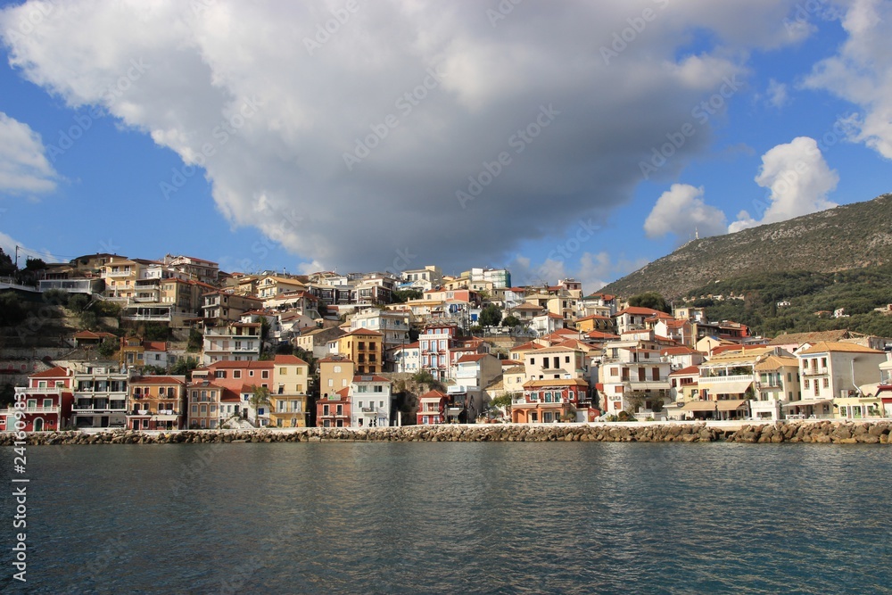 View of the Greek seaside traditional town of Parga in the Ionian sea at the mediterranean in Greece in the afternoon big cloud at the sky in a sunny day and calm sea at the harbor