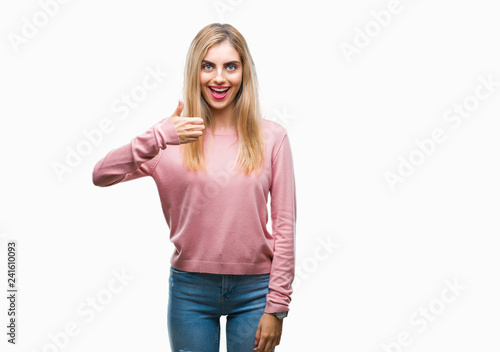 Young beautiful blonde woman wearing pink winter sweater over isolated background doing happy thumbs up gesture with hand. Approving expression looking at the camera with showing success.