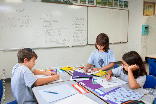 Children writing in a classroom