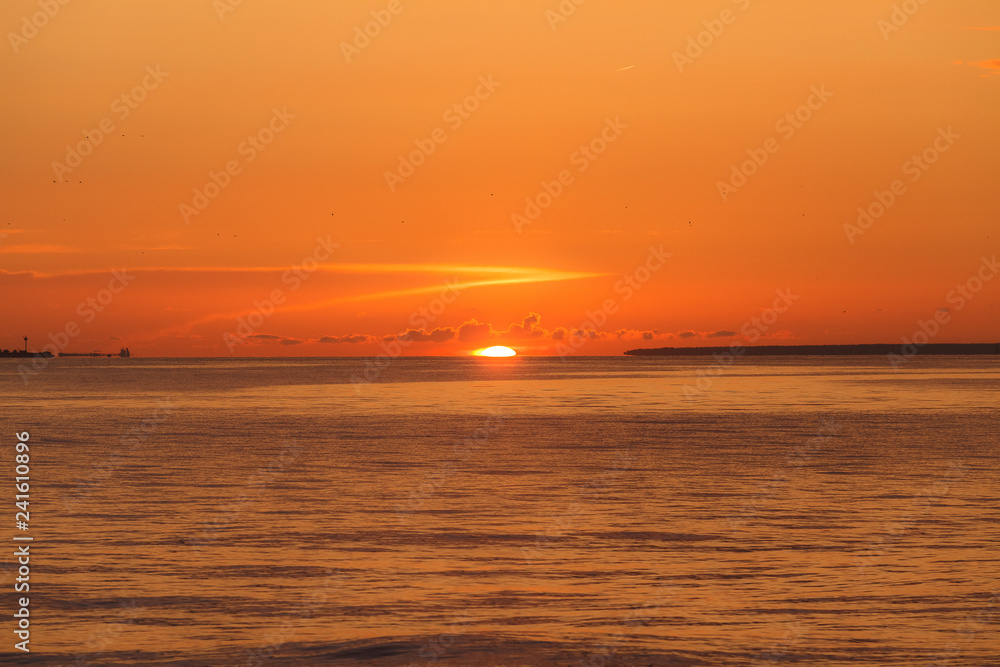 Colourful orange sunset with bright clear sky over Baltic sea.