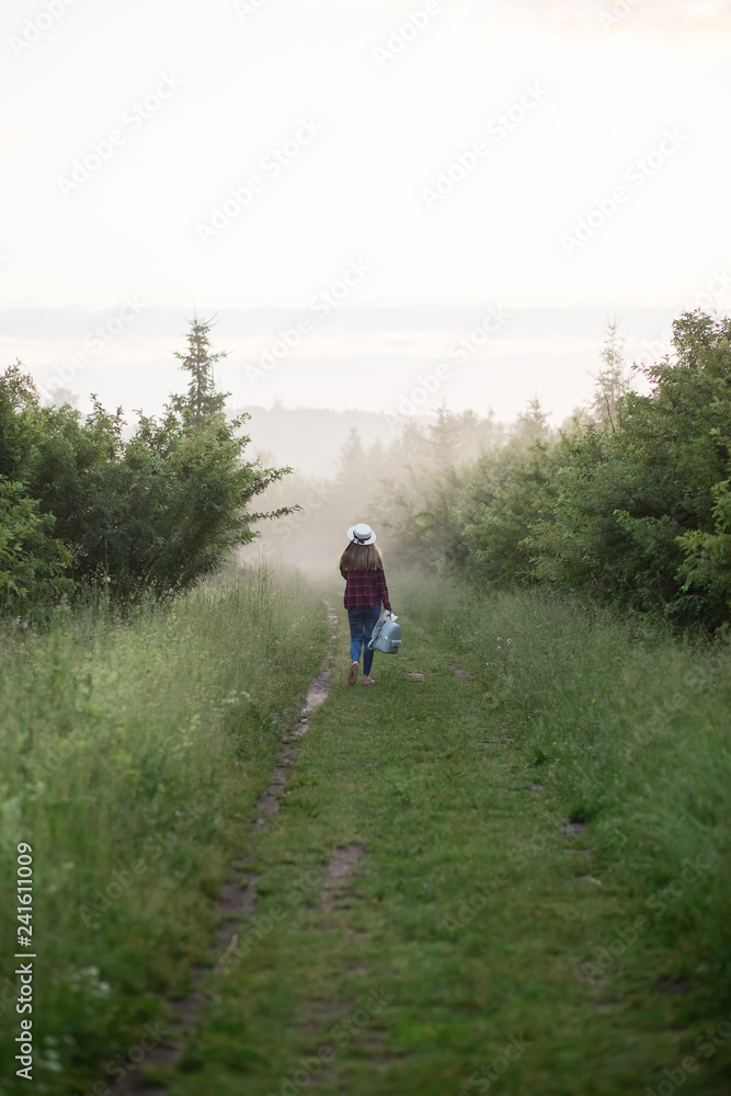 single girl meets sunrise in a misty morning in a field in summer
