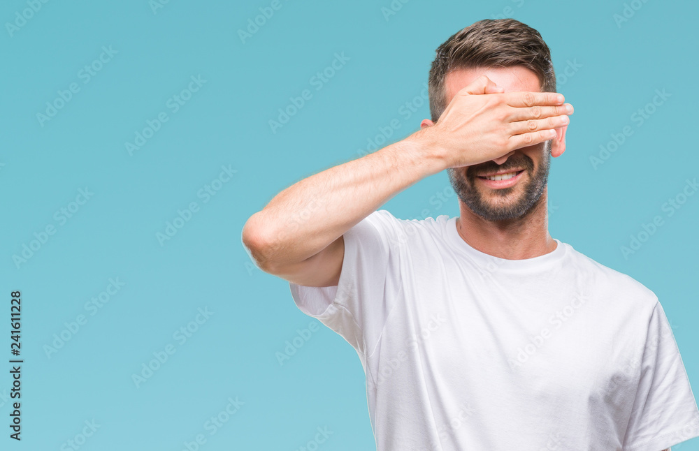 Young handsome man over isolated background smiling and laughing with hand on face covering eyes for surprise. Blind concept. Young handsome man over isolated background smiling and laughing with hand on face covering eyes for surprise. Blind concept.