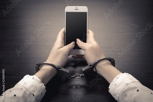 handcuffed hands with a mobile phone