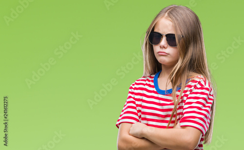 Young beautiful girl wearing sunglasses over isolated background skeptic and nervous, disapproving expression on face with crossed arms. Negative person.
