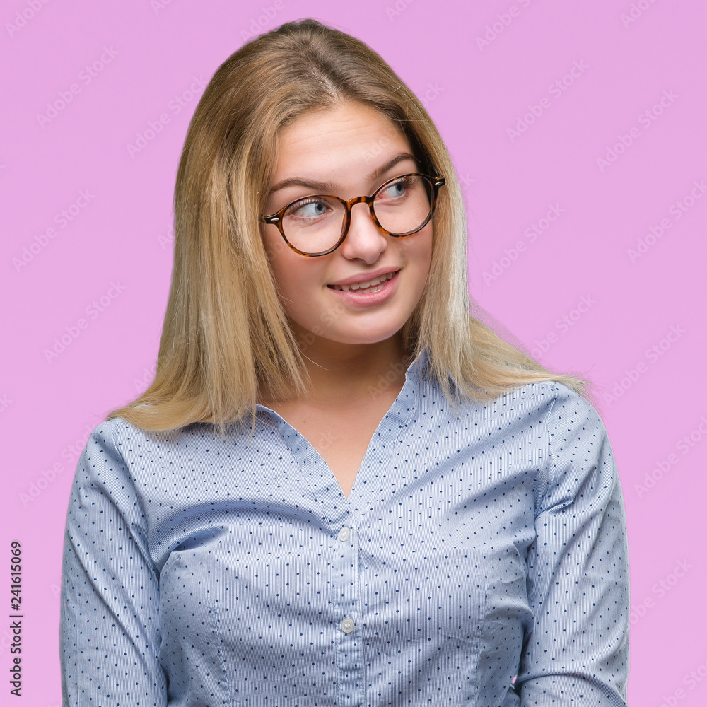 Young caucasian business woman wearing glasses over isolated background looking away to side with smile on face, natural expression. Laughing confident.